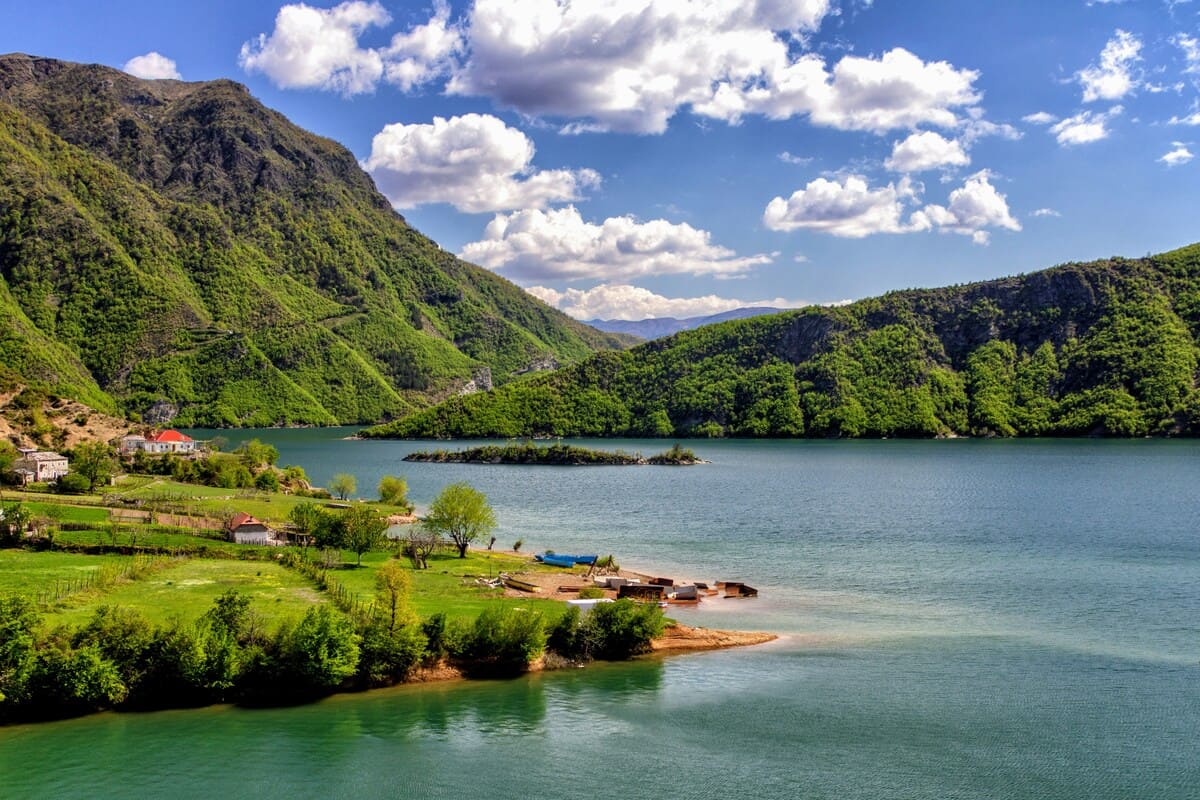 Lake Koman surrounded by steep green mountains in northern Albania