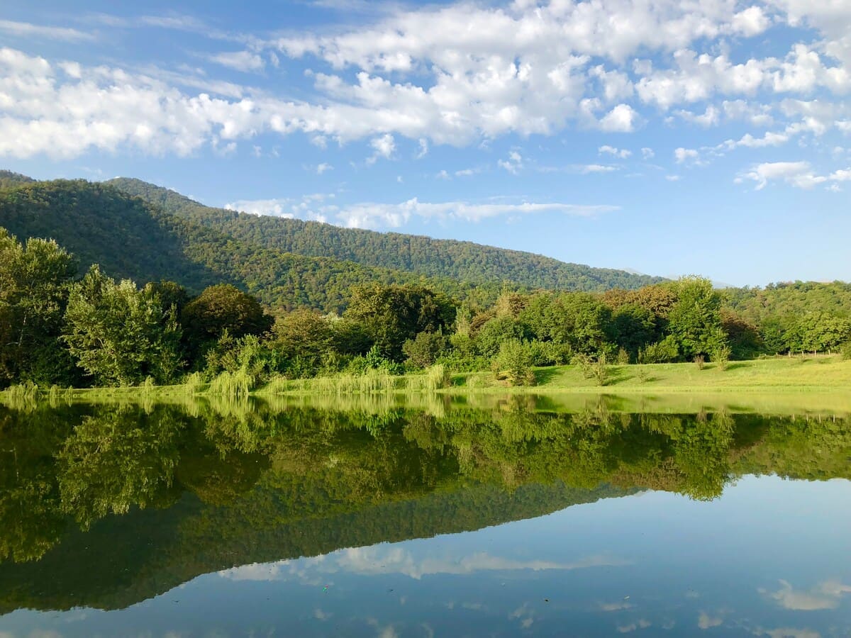 Nohur Lake near Gabala with forested mountains reflected in calm water