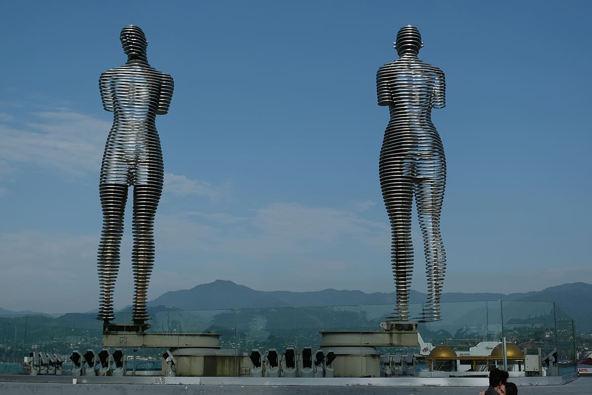 Escultura de Ali y Nino en Batumi, con las montañas y el horizonte de fondo
