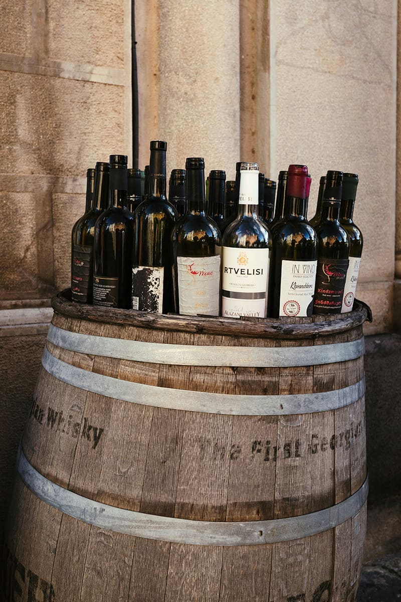 Botellas de vino georgiano sobre un barril de madera