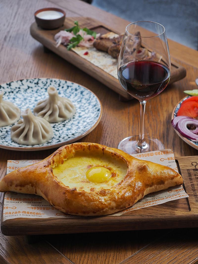 Khachapuri, khinkali y vino georgiano sobre una mesa