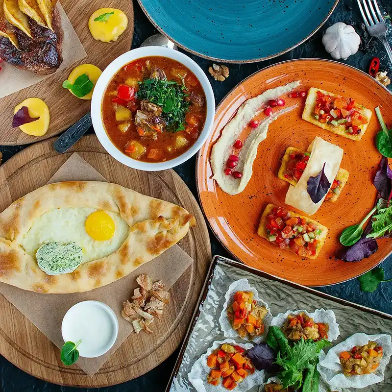 Mesa con khachapuri, pkhali, verduras y platos tradicionales georgianos