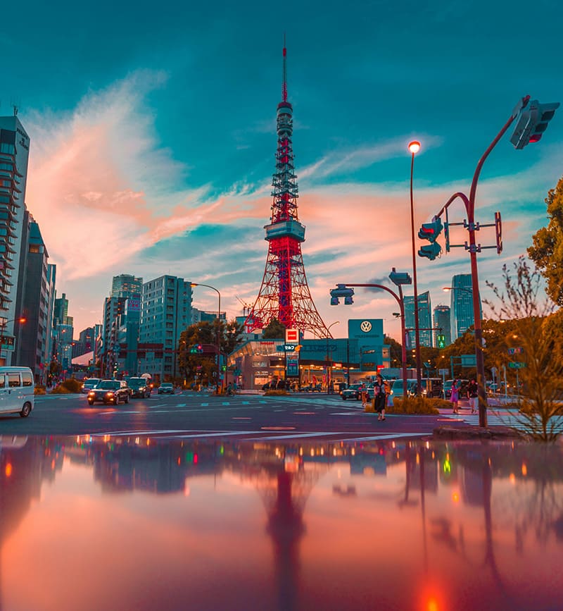 Tokyo Tower at sunset with cars and city street in Tokyo Japan