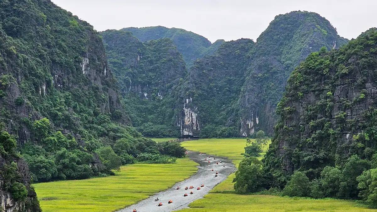Boats on a river surrounded by limestone karsts in Ninh Binh Vietnam