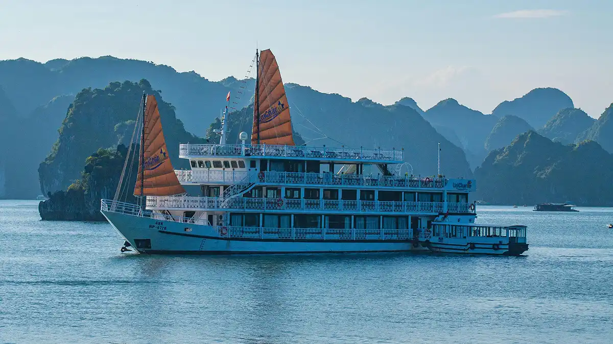 Barco de crucero navegando entre islas de piedra caliza en el norte de Vietnam