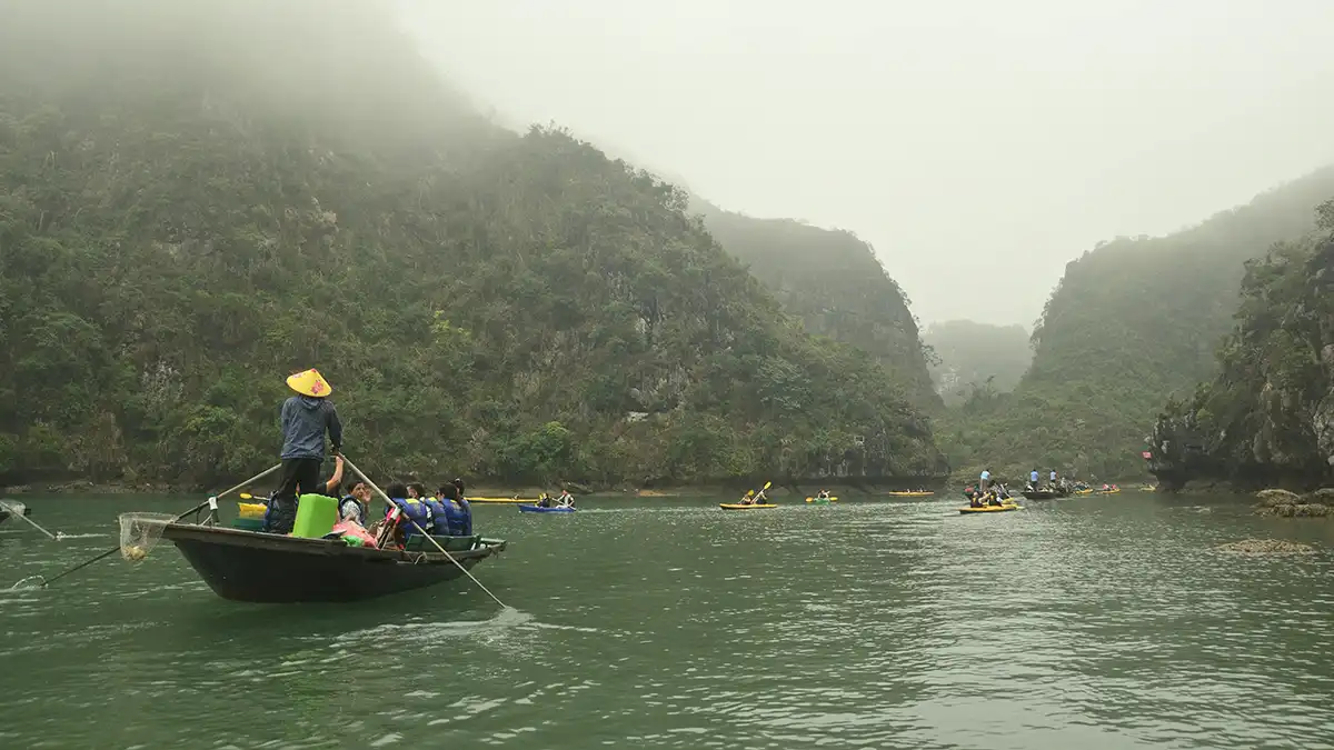 Misty morning boat scene among limestone islands in northern Vietnam