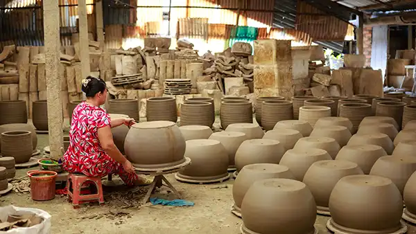 Artesano dando forma a piezas de barro en un taller de cerámica de Bat Trang cerca de Hanói
