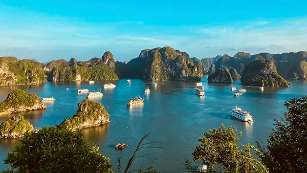 Barcos de crucero entre islas de piedra caliza en la bahía de Ha Long, Vietnam