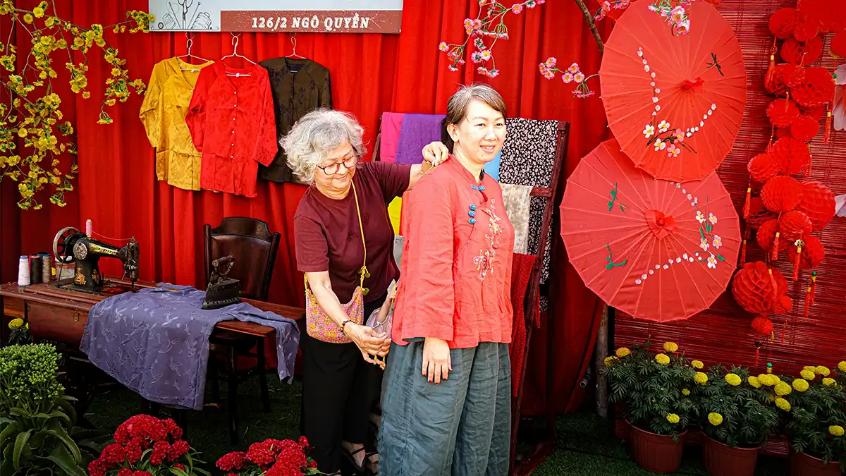 Tailor measuring a traveler for clothing in Hoi An