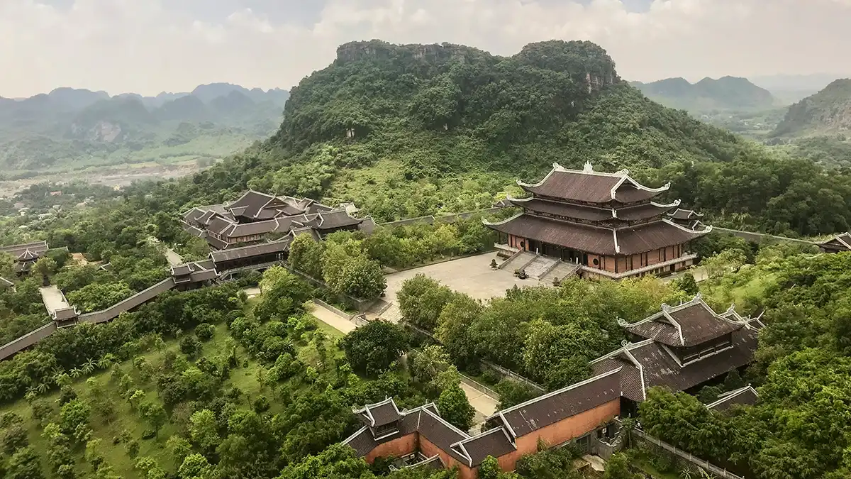 Large temple complex at Bai Dinh Pagoda surrounded by green limestone hills in Ninh Binh