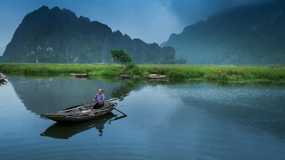 Small rowing boat on calm water at Van Long Nature Reserve in Ninh Binh