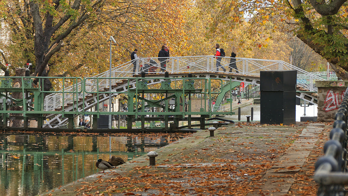 Wide view of Canal Saint-Martin with water reflections and people walking