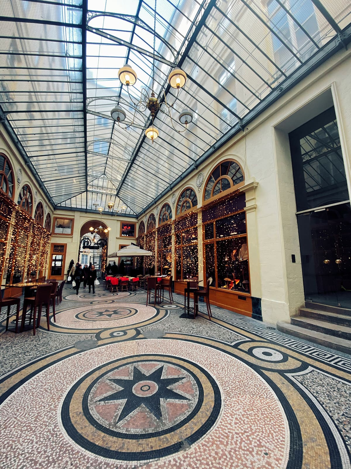 Ornate interior of Galerie Vivienne with glass ceiling and detailed architecture