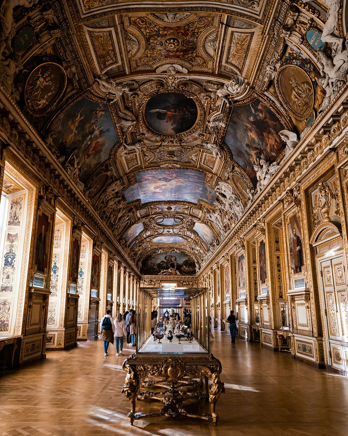 Ornate ceiling and grand hall interior of Louvre Museum with detailed artwork