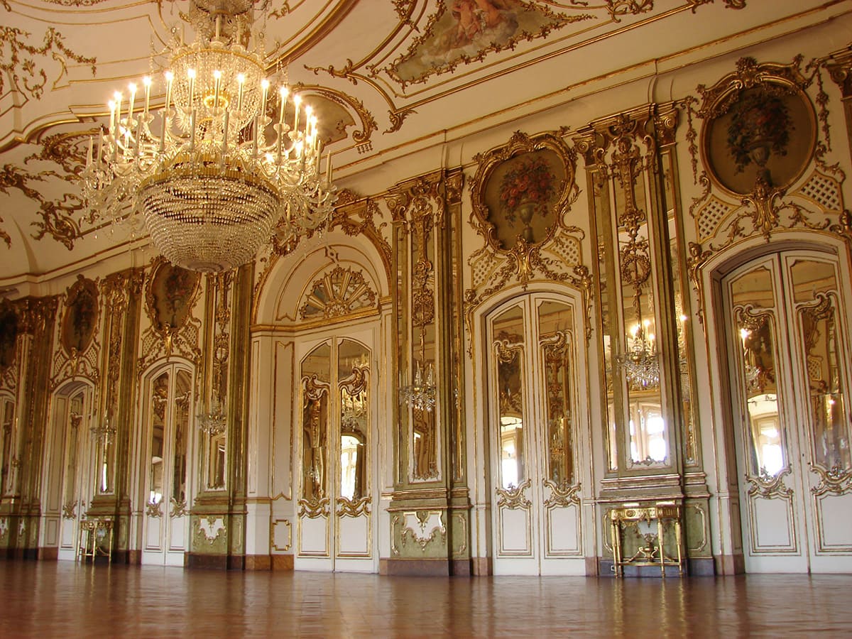 Grand interior room inside Palace of Versailles with chandelier and ornate decor