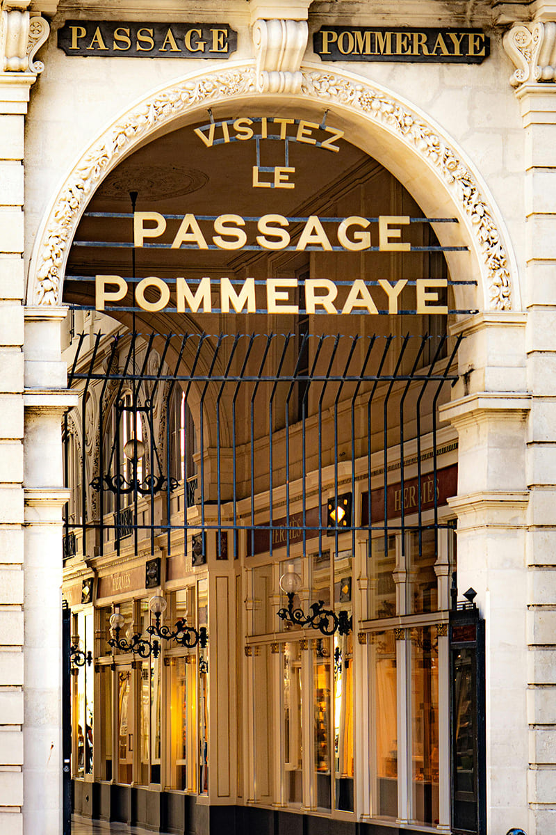 Long corridor of Passage des Panoramas with shops and glass ceiling in Paris