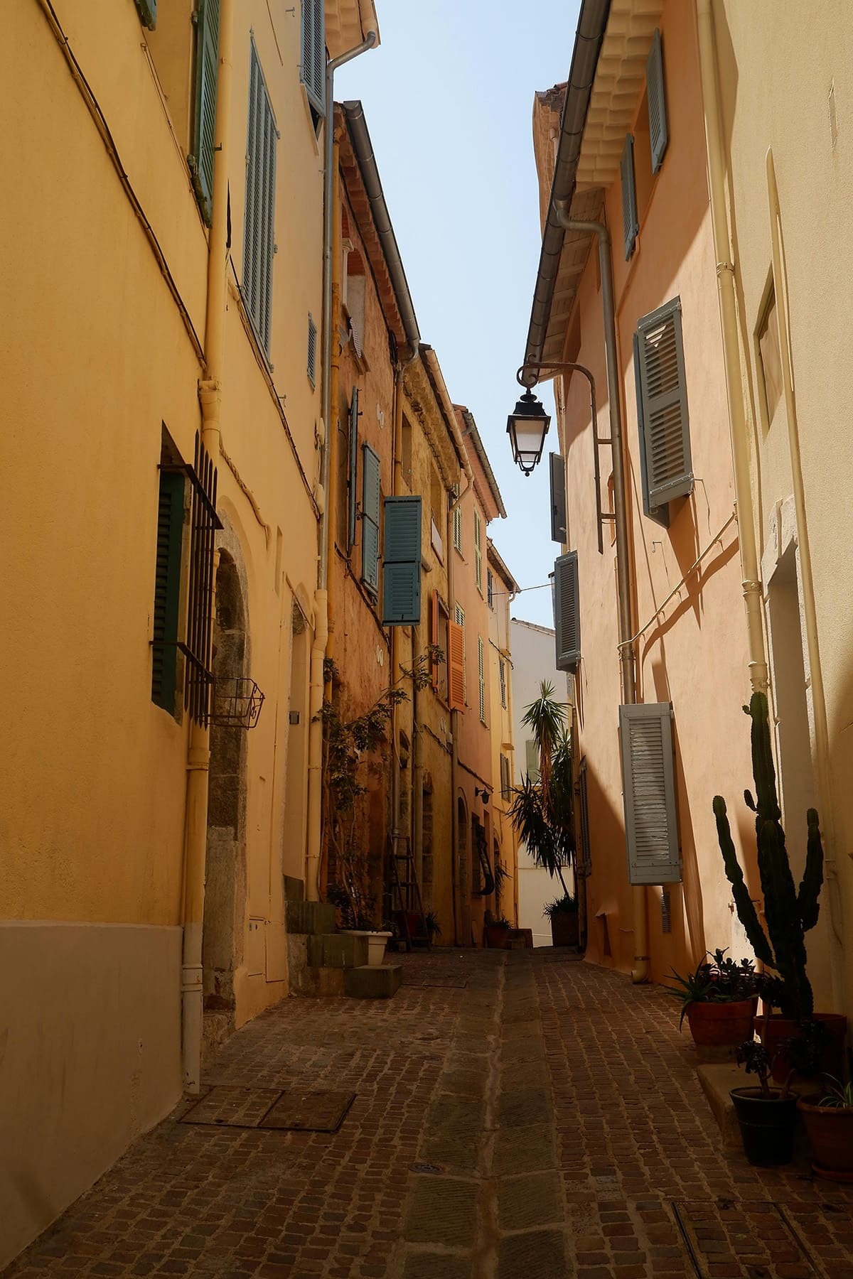 Narrow colorful alley with pastel buildings and shutters in Paris