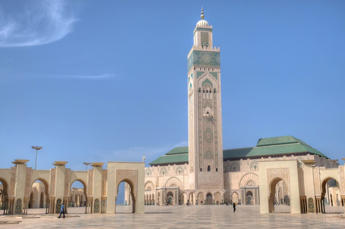 Hassan II Mosque minaret and open courtyard beneath a clear blue sky