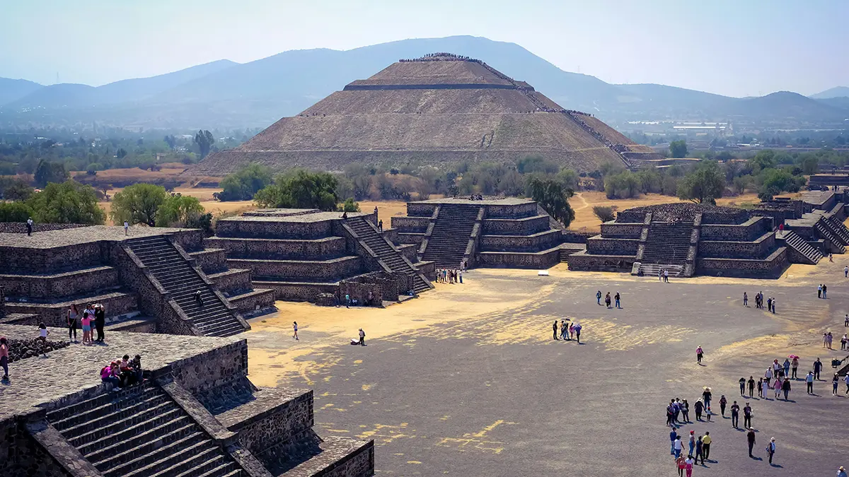 Pirámide, plataformas escalonadas y visitantes en la zona arqueológica de Teotihuacán.