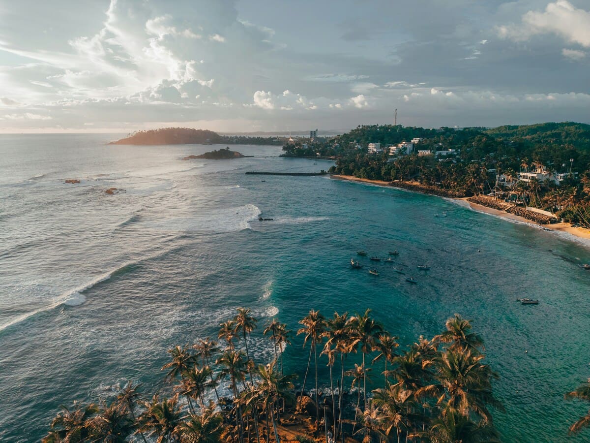 Vista aérea de la playa de Mirissa y la costa bordeada de palmeras en Sri Lanka