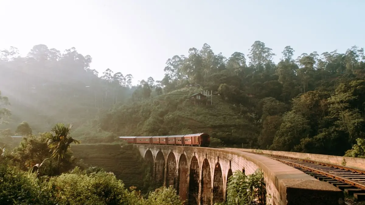 Tren cruzando el Puente de los Nueve Arcos entre bosque y niebla cerca de Ella