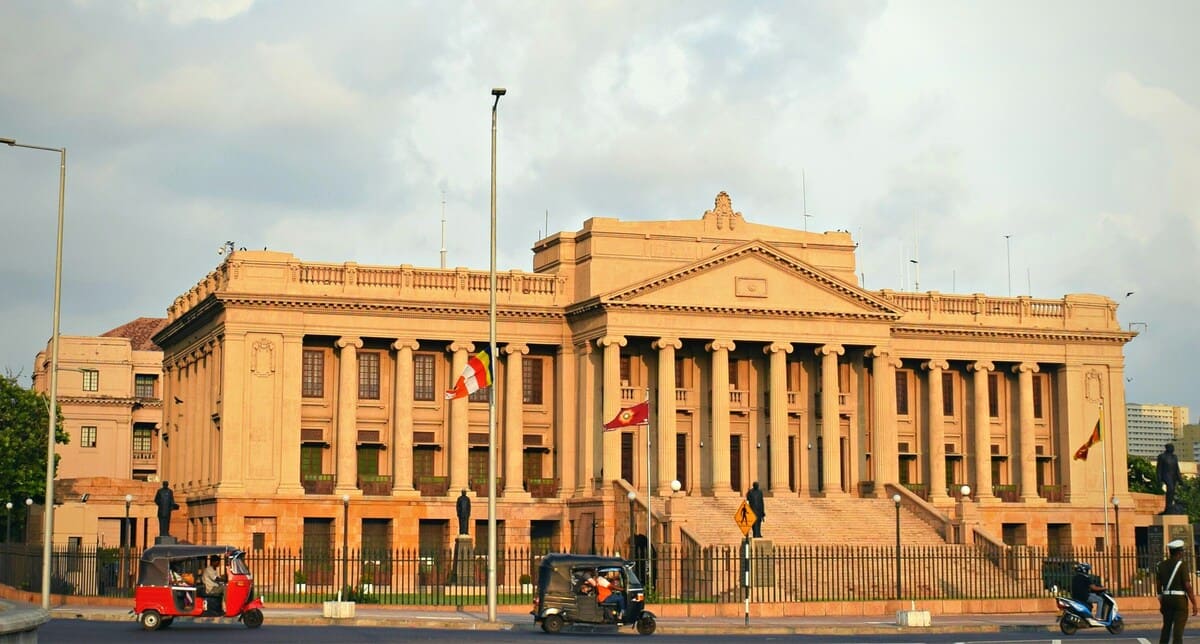 Edificio de época colonial en Colombo Fort con tuk-tuks circulando por la calle