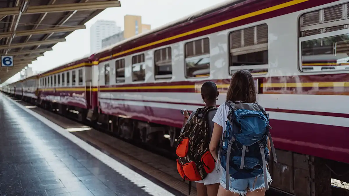 Backpackers waiting beside a train before travelling from Bangkok to Chiang Mai