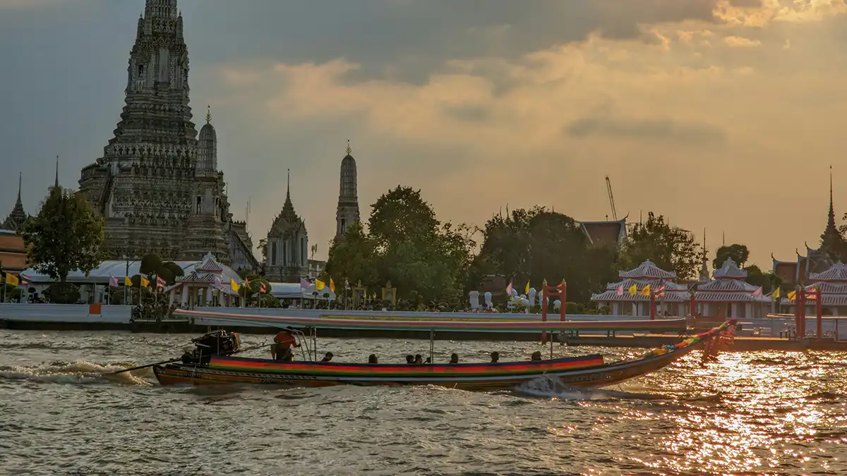 Passenger boat passing Wat Arun on the Chao Phraya River in Bangkok
