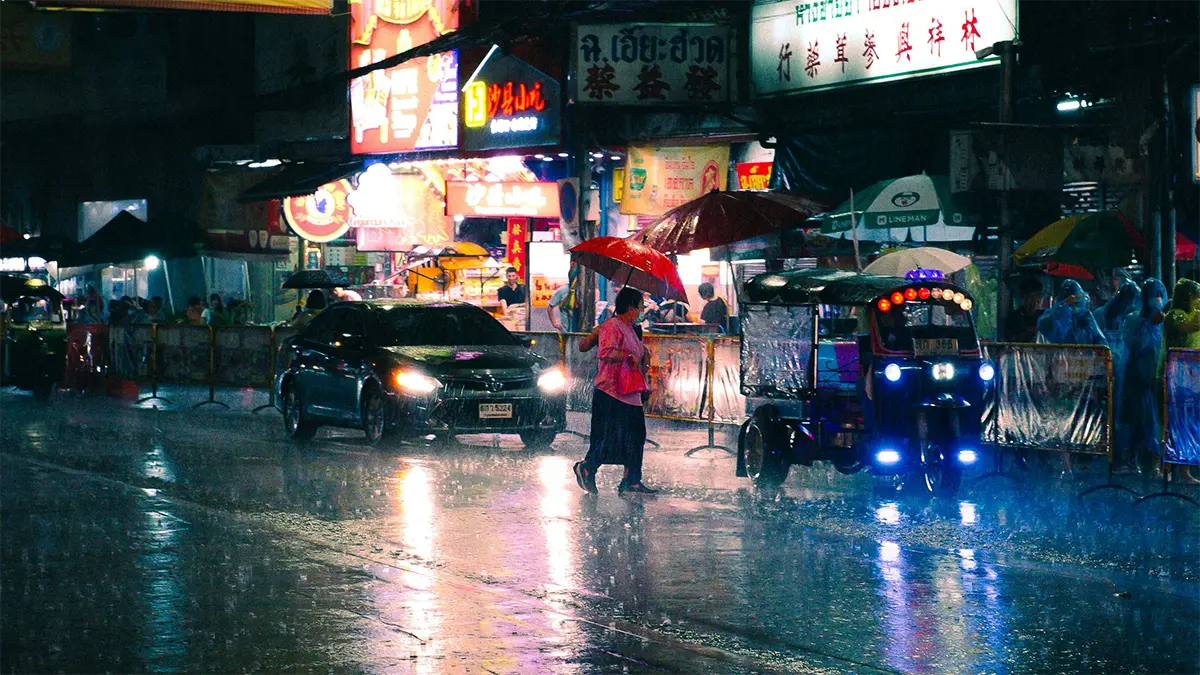 People walking with umbrellas on a rainy street in Bangkok