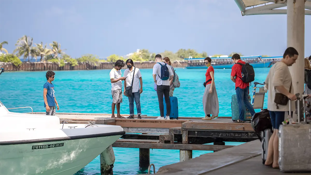 Travelers boarding a ferry with luggage in Thailand