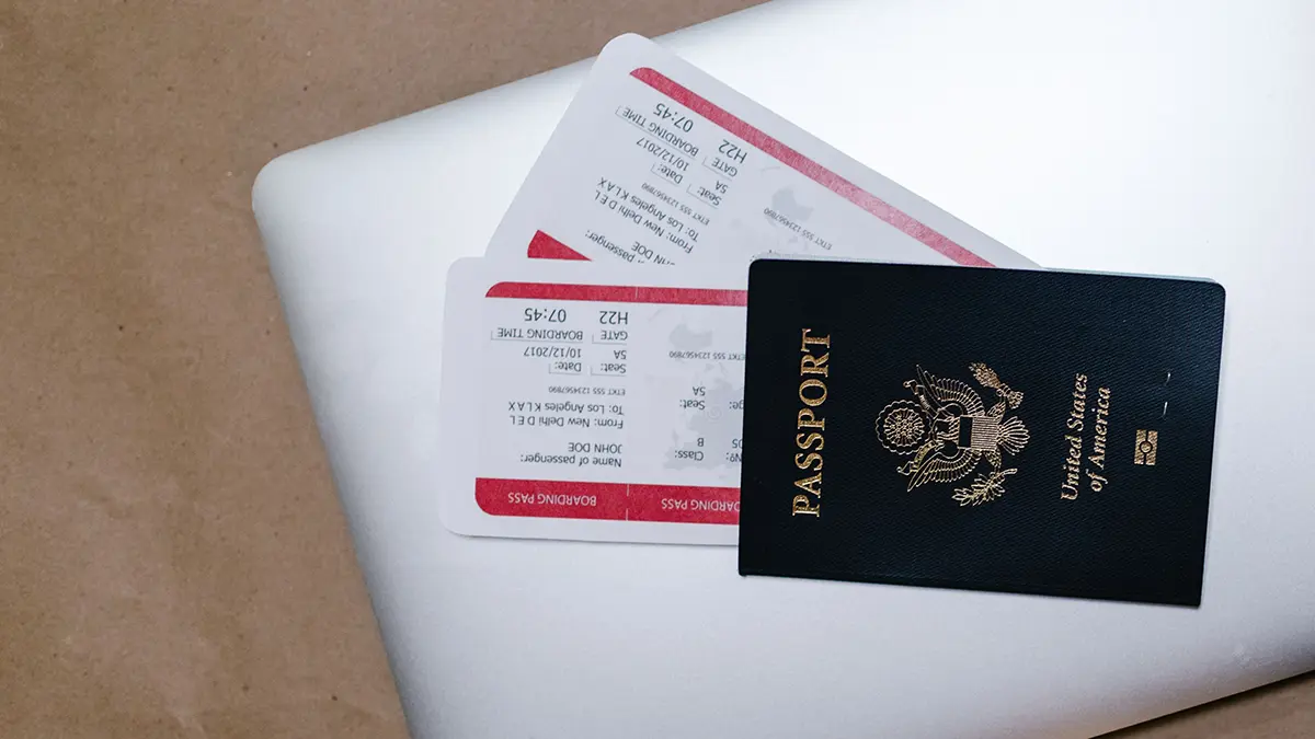 Passport and airline boarding passes arranged on a laptop